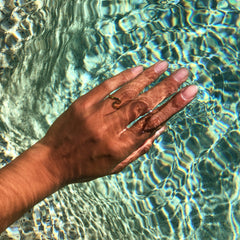 Gold ocean wave ring worn on a hand