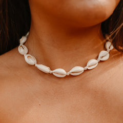 Natural cowrie shell necklace on an adjustable cord worn at the neck
