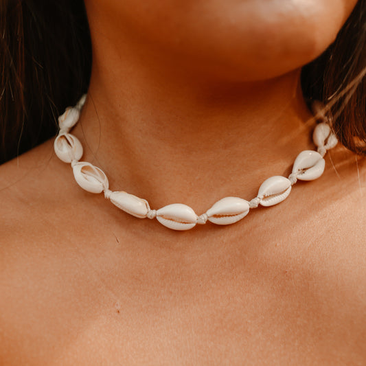 Natural cowrie shell necklace on an adjustable cord worn at the neck