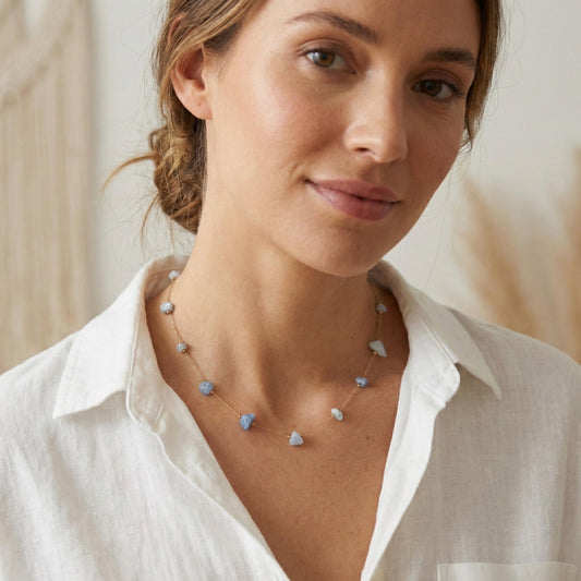 Blue moonstone pendant on a fine gold chain necklace worn at the neck