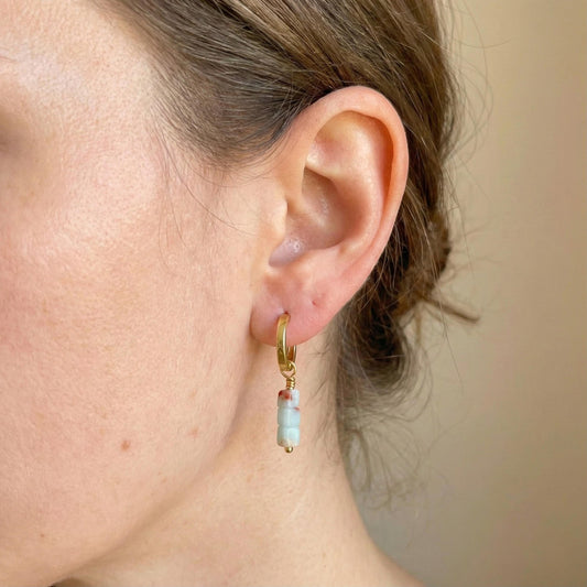 Gold vermeil hoop earring with an aqua stone drop worn on the ear