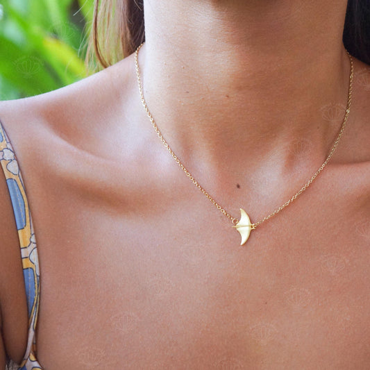Gold manta ray pendant necklace worn on a model's neck