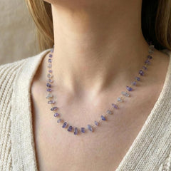 Purple amethyst stone pendant on a fine gold chain necklace worn at the neck