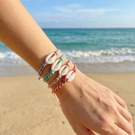 Colorful braided cowrie shell bracelet on a wrist