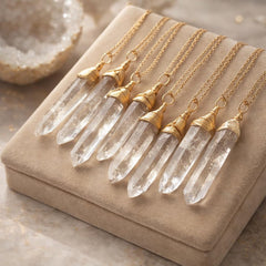 Raw quartz crystal point pendant necklace worn at the neck